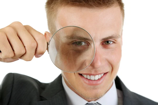 Young businessman looking through magnifying glass isolated on white — Stock Photo, Image