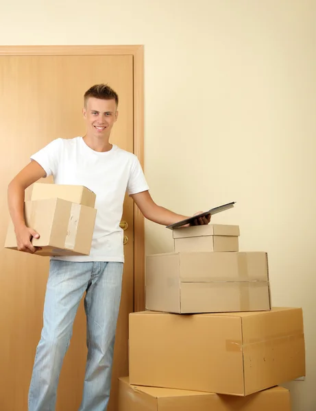 Joven repartidor con paquetes y portapapeles , — Foto de Stock