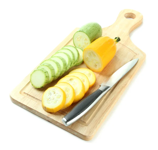 Sliced and whole raw zucchini on wooden cutting board, isolated on white — Stock Photo, Image