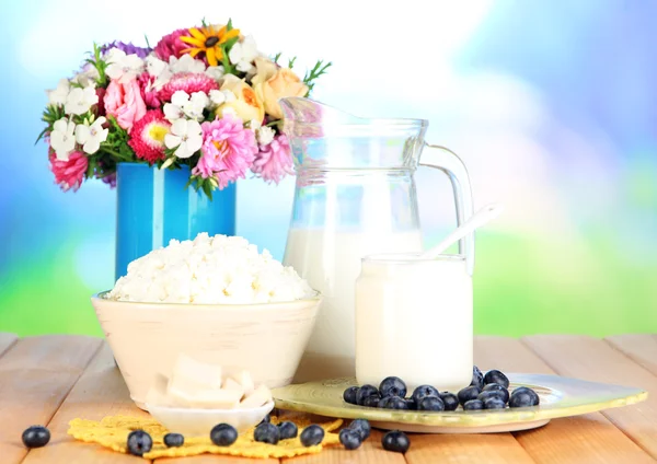 Produits laitiers frais avec myrtille sur table en bois sur fond naturel — Photo