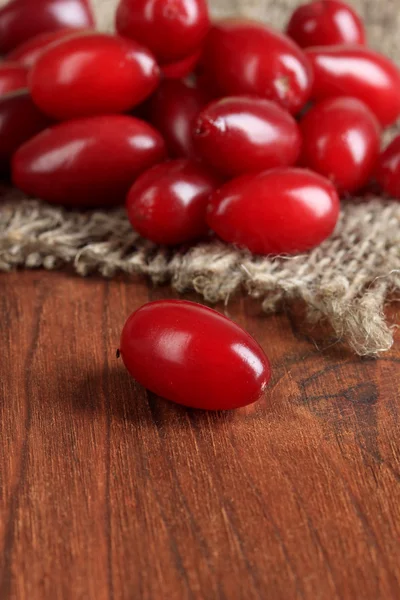 Bayas frescas de cornel sobre fondo de madera — Foto de Stock