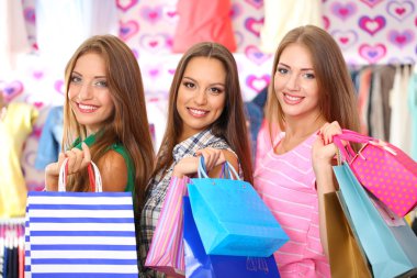 dükkanda alışveriş torbaları ile üç güzel bir genç kadın