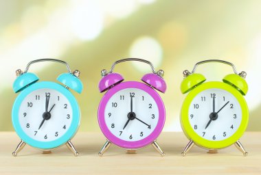 Masanın üzerine ışık arka plan üzerinde renkli çalar saatler