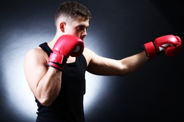 koyu arka plan üzerinde genç yakışıklı kaslı boksör