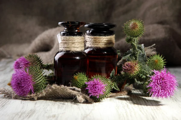 Medicine bottles with thistle flowers — Stock Photo, Image