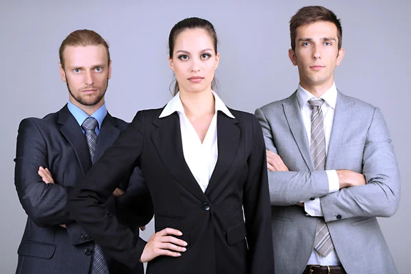 Команда бизнесменов, стоящая в ряд на сером фоне — стоковое фото