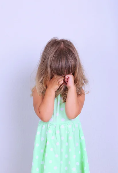 Kleines nettes Mädchen auf Teppich, auf grauem Hintergrund — Stockfoto