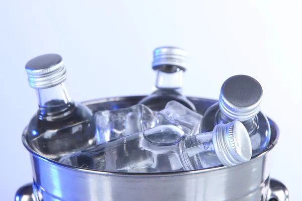 Μίνι μπαρ μπουκάλια σε κουβά με παγάκια, που απομονώνονται σε λευκό — Φωτογραφία Αρχείου