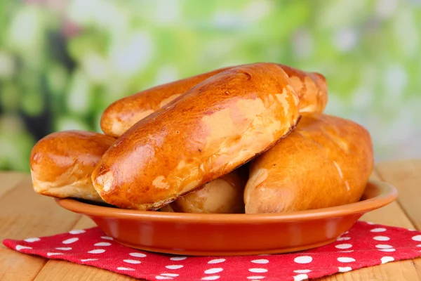 Fresh baked pasties, on wooden table, on bright background — Stock Photo, Image