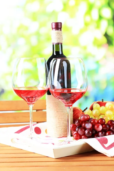 Copos de vinho no guardanapo na bandeja na mesa de madeira no fundo da natureza — Fotografia de Stock