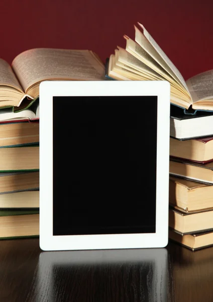 Tablette et livres sur fond lumineux — Photo