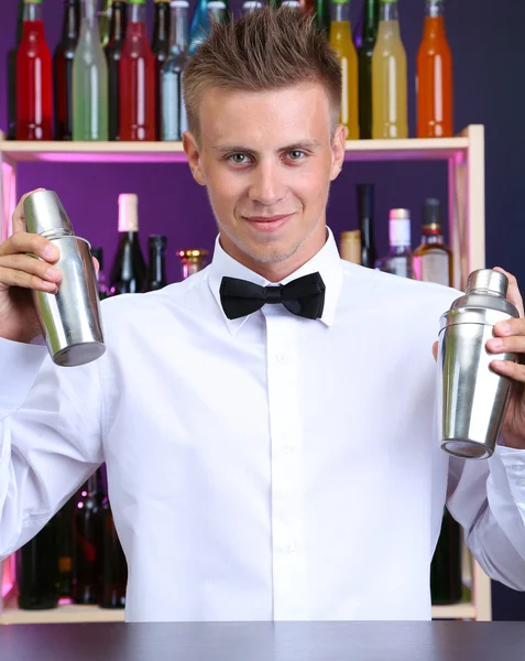 Portret van knappe barman met twee shakers, op bar — Stockfoto