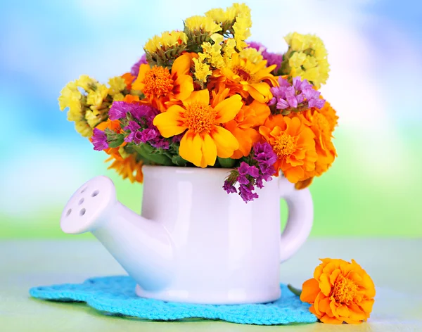 Аромат цветов Мэриголд в банке для полива на деревянном столе на естественном фоне — стоковое фото
