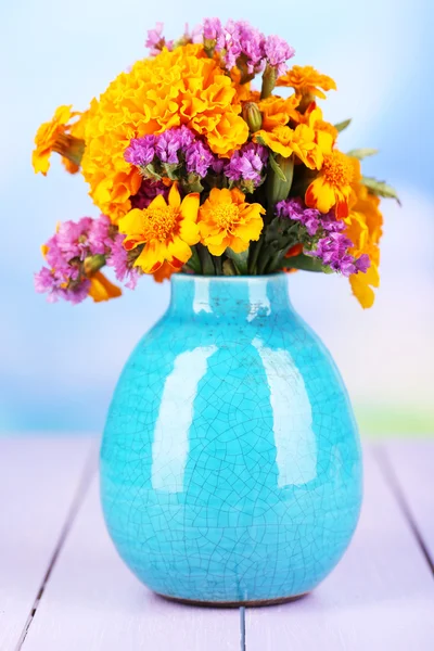 Bouquet of marigold flowers in vase on wooden table on natural background — Stock Photo, Image