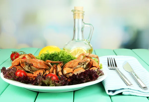 Crabes bouillis sur assiette blanche avec feuilles de salade et tomates, sur table en bois, sur fond lumineux — Photo