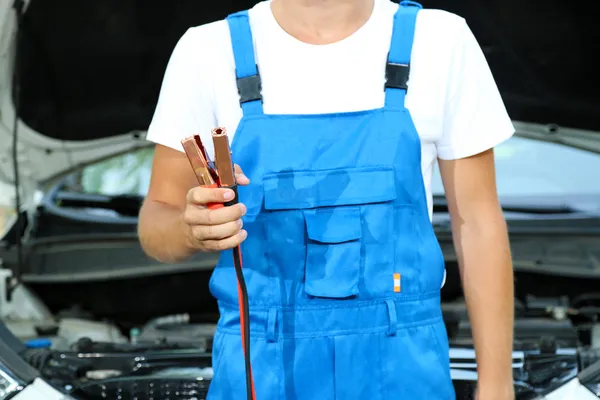 Jonge driver met batterijstartkabels om lege batterij op te laden — Stockfoto