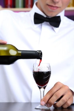 Barmen kırmızı şarap cam içine yağıyor