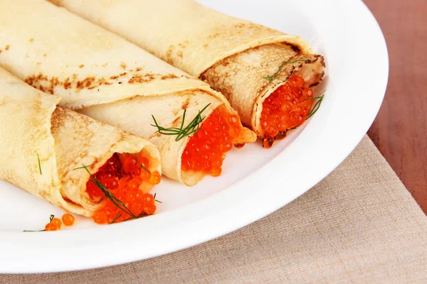 Läckra pannkakor med röd kaviar på bordet närbild — Stockfoto