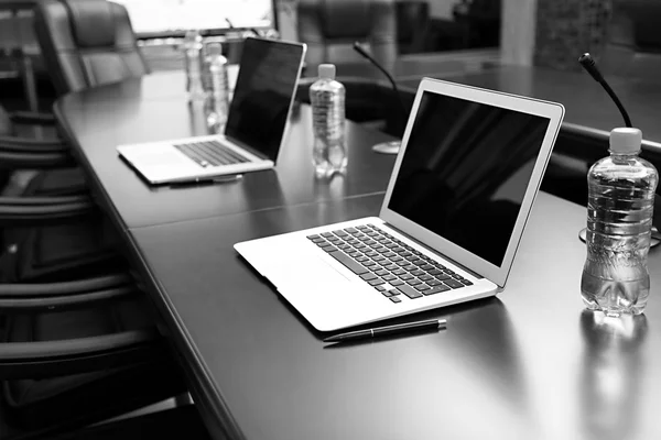 Sala conferenze vuota con computer portatili sul tavolo nei toni del grigio — Foto Stock
