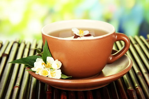 Tasse de thé au jasmin, sur tapis de bambou, sur fond lumineux — Photo