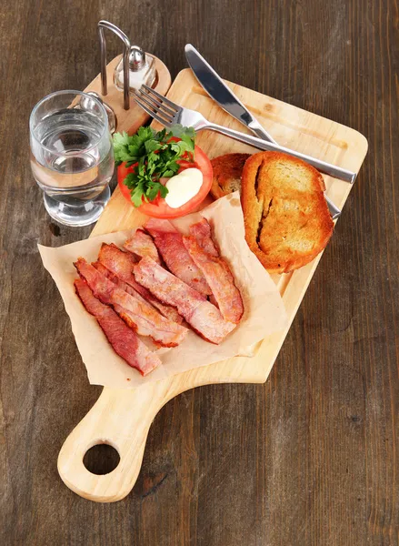 Бекон на тарелках на деревянном столе — стоковое фото