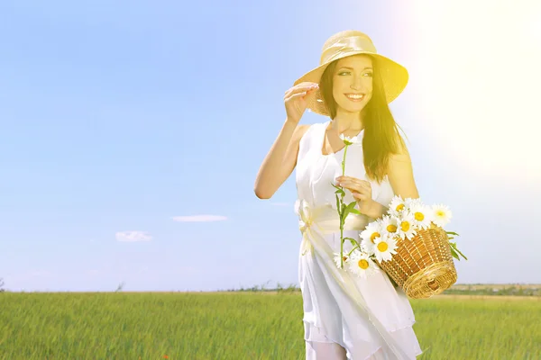 Retrato de una hermosa joven con flores en el campo —  Fotos de Stock