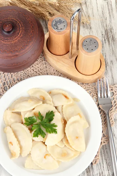 Sabrosas albóndigas con cebolla frita sobre plato blanco, sobre fondo de madera —  Fotos de Stock