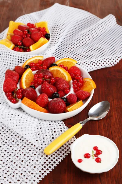 Useful fruit salad in plates on wooden table close-up — Stock Photo, Image