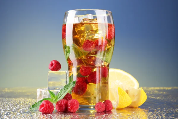 Iced tea with raspberries and mint on blue background — Stock Photo, Image