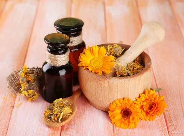 Frascos de medicina y flores de caléndula sobre fondo de madera — Foto de Stock
