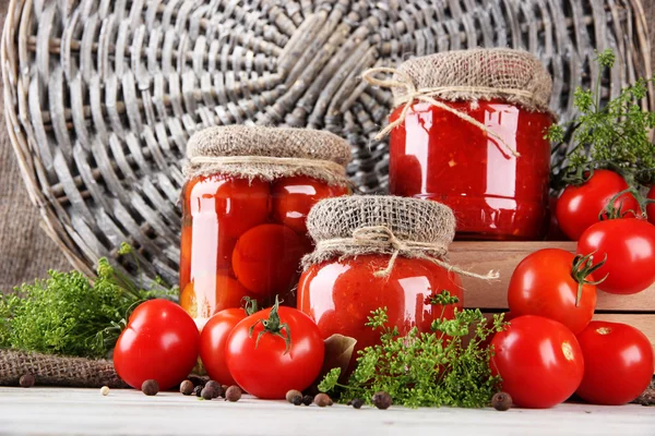 Sabrosos tomates enlatados y frescos sobre mesa de madera — Foto de Stock