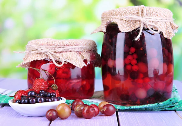 Marmellata di bacche fatta in casa su tavolo di legno su sfondo luminoso — Foto Stock