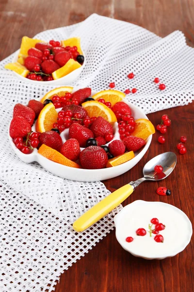 Useful fruit salad in plate on wooden table close-up — Stock Photo, Image