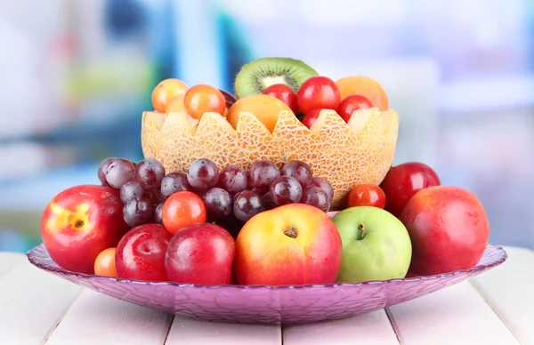 Parlak zemin üzerine ahşap masa üzerinde sulu meyve çeşitleri — Stok fotoğraf