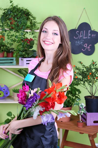 Mooi meisje bloemist met bloemen in bloemen winkel — Stockfoto