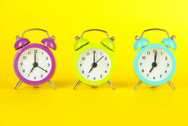 Colorful alarm clock on yellow background — Stock Photo, Image