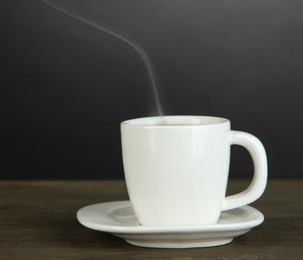 Taza de café sobre mesa de madera sobre fondo negro —  Fotos de Stock