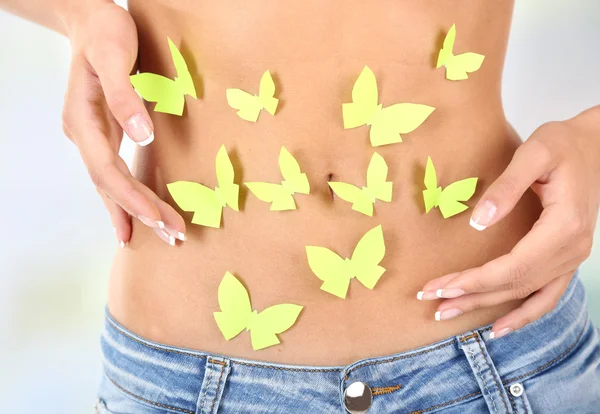 Butterfly on stomach on light background — Stock Photo, Image