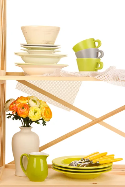 Lots beautiful dishes on wooden cabinet on white background — Stock Photo, Image