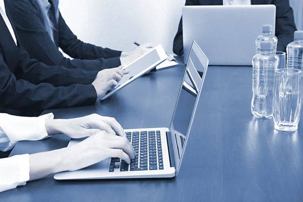 Manos femeninas con portátil sobre fondo de oficina. Foto conceptual de la conferencia de negocios en tonos grises —  Fotos de Stock