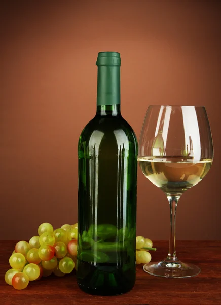 Composición de botella de vino, copa de vino blanco, uva sobre fondo de color — Foto de Stock