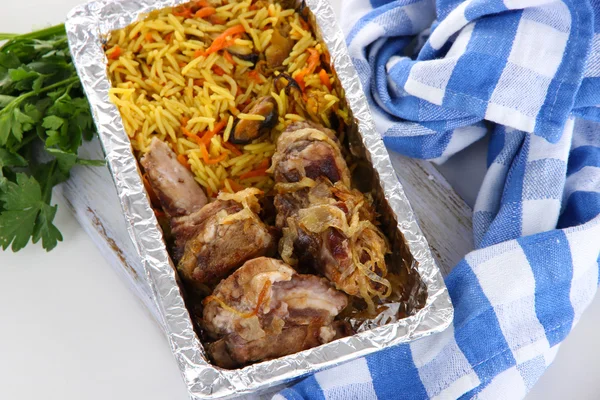 Comida en caja de papel de aluminio sobre servilleta sobre tabla de madera aislada en blanco —  Fotos de Stock