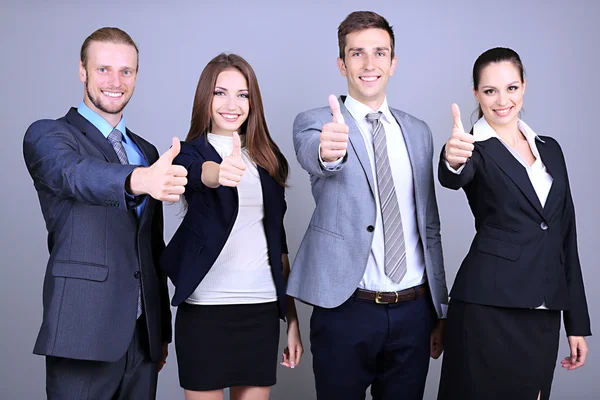 Zakelijke team staande in rij op grijze achtergrond — Stockfoto