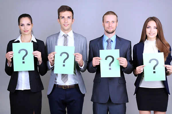 Business team in piedi in fila con punto interrogativo su sfondo grigio — Foto Stock