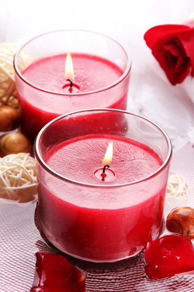 Hermosas velas rojas con pétalos de flores en agua —  Fotos de Stock