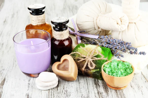 Stilleben med lavendel ljus, tvål, massage bollar, flaskor, tvål och färsk lavendel, på trä bakgrund — Stockfoto