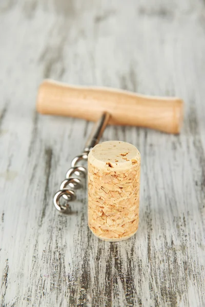 Corkscrew with wine corks on wooden table close-up — Stock Photo, Image