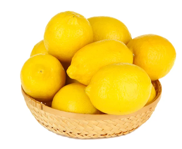 Rijp citroenen in rieten mand geïsoleerd op wit — Stockfoto