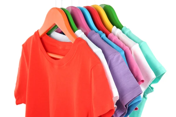 Different shirts on colorful hangers on white background — Stock Photo, Image
