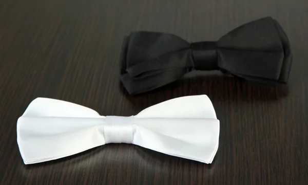 Black and white bow ties on wooden background — Stock Photo, Image